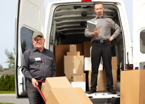 Removalists carrying furniture through a narrow stairwell in Islington
