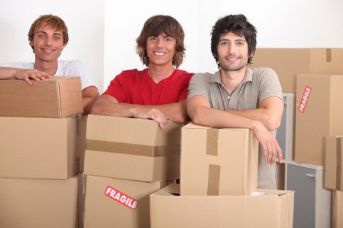 Removal team carrying student boxes in a narrow Islington stairwell
